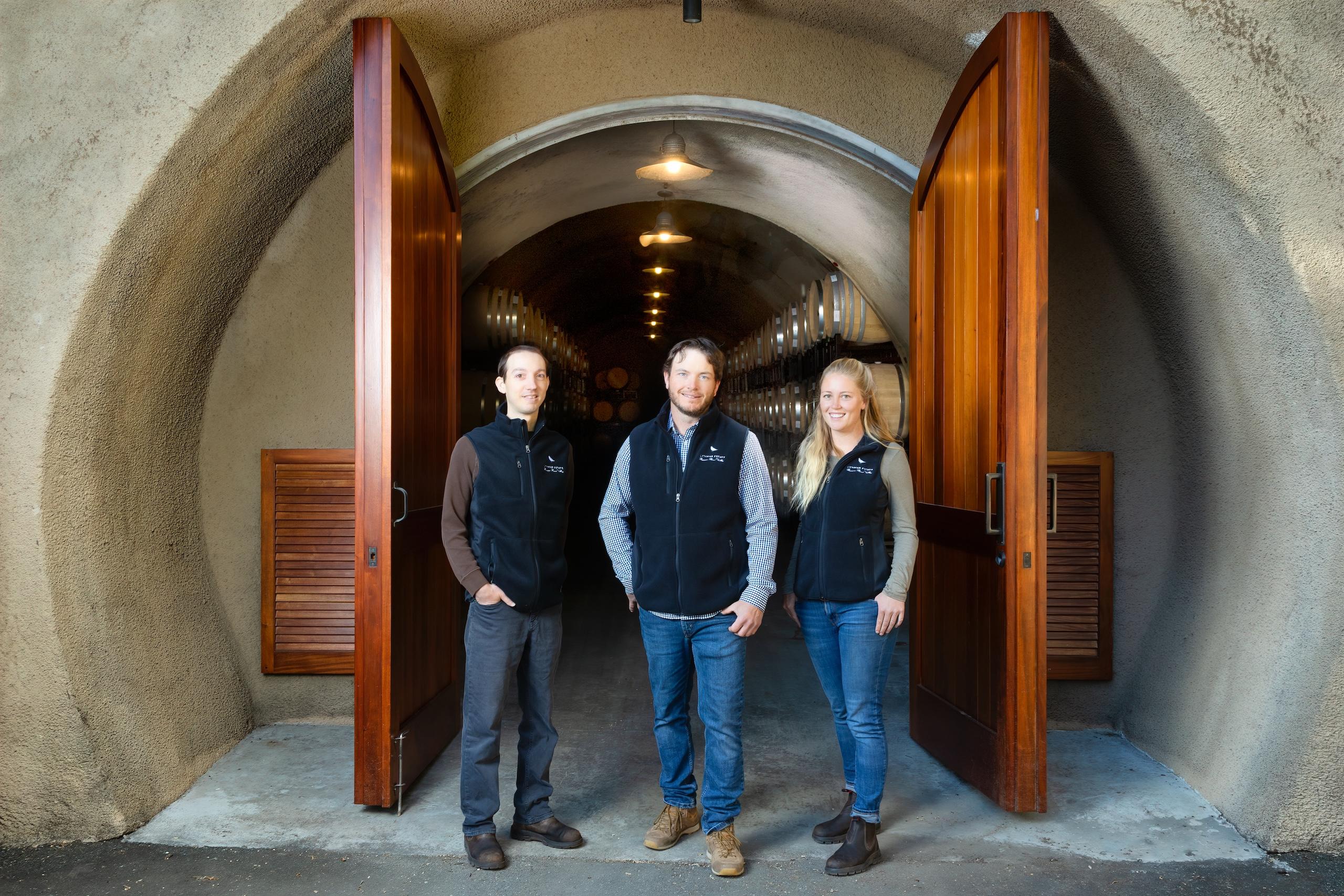 Winemaking team standing in doorway of barrel cellar