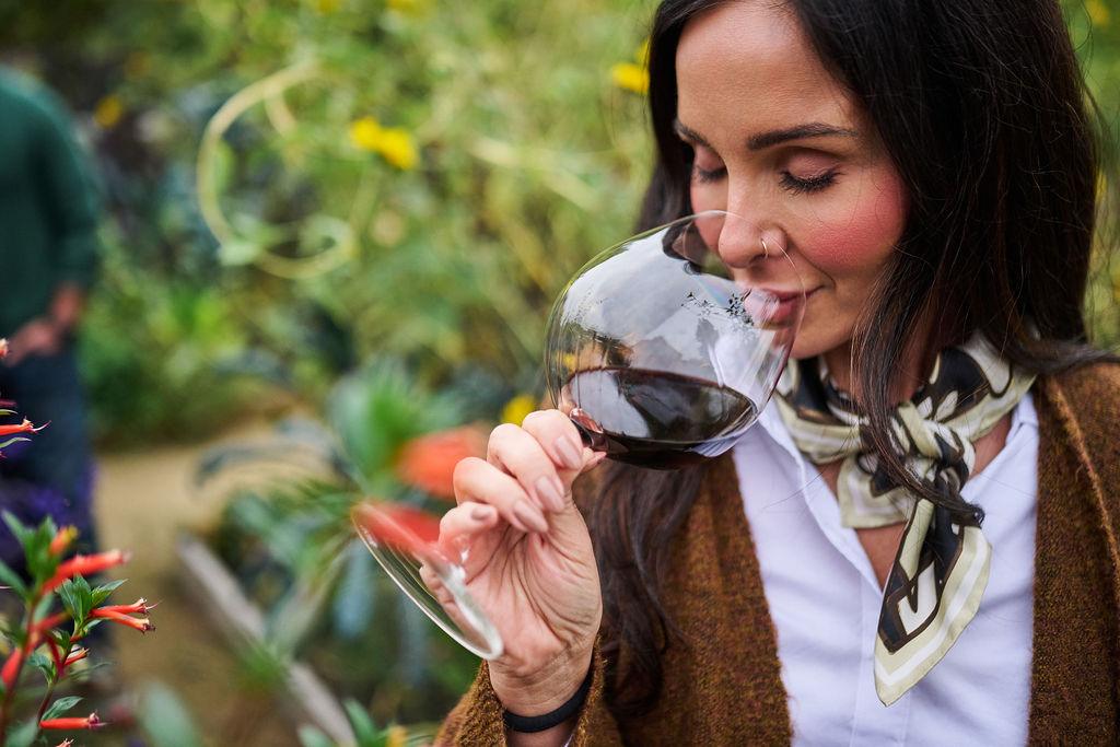 A woman deeply enjoys the aromas of Lynmar Estate Russian River Pinot Noir in her wine glass.